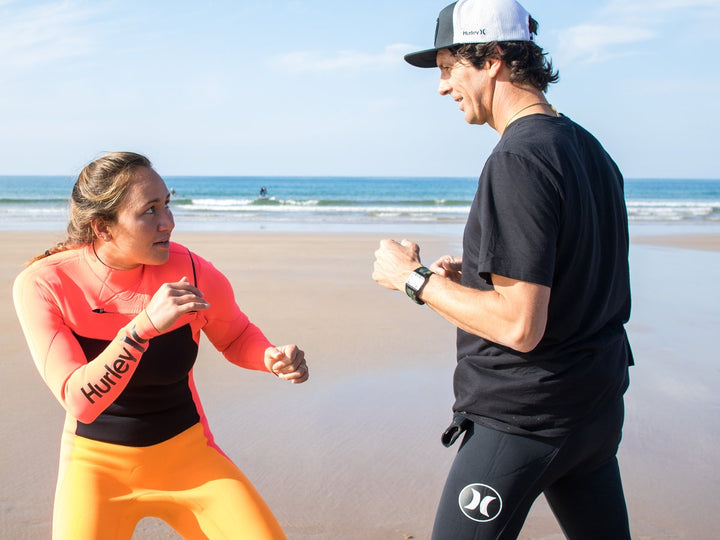 Sur la plage, une élève travaille sa position face à son coach