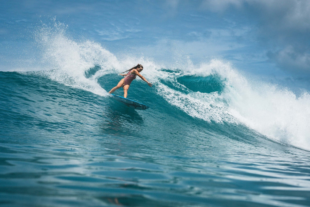 Une surfeuse en plein virage sur une vague des Mentawai