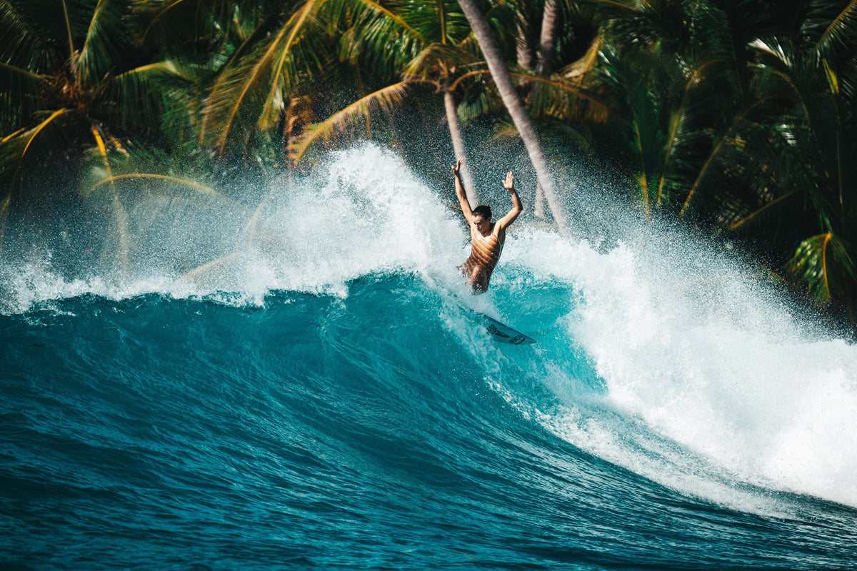 Un surfeur sort d’une vague sous les cocotiers, aux Mentawai