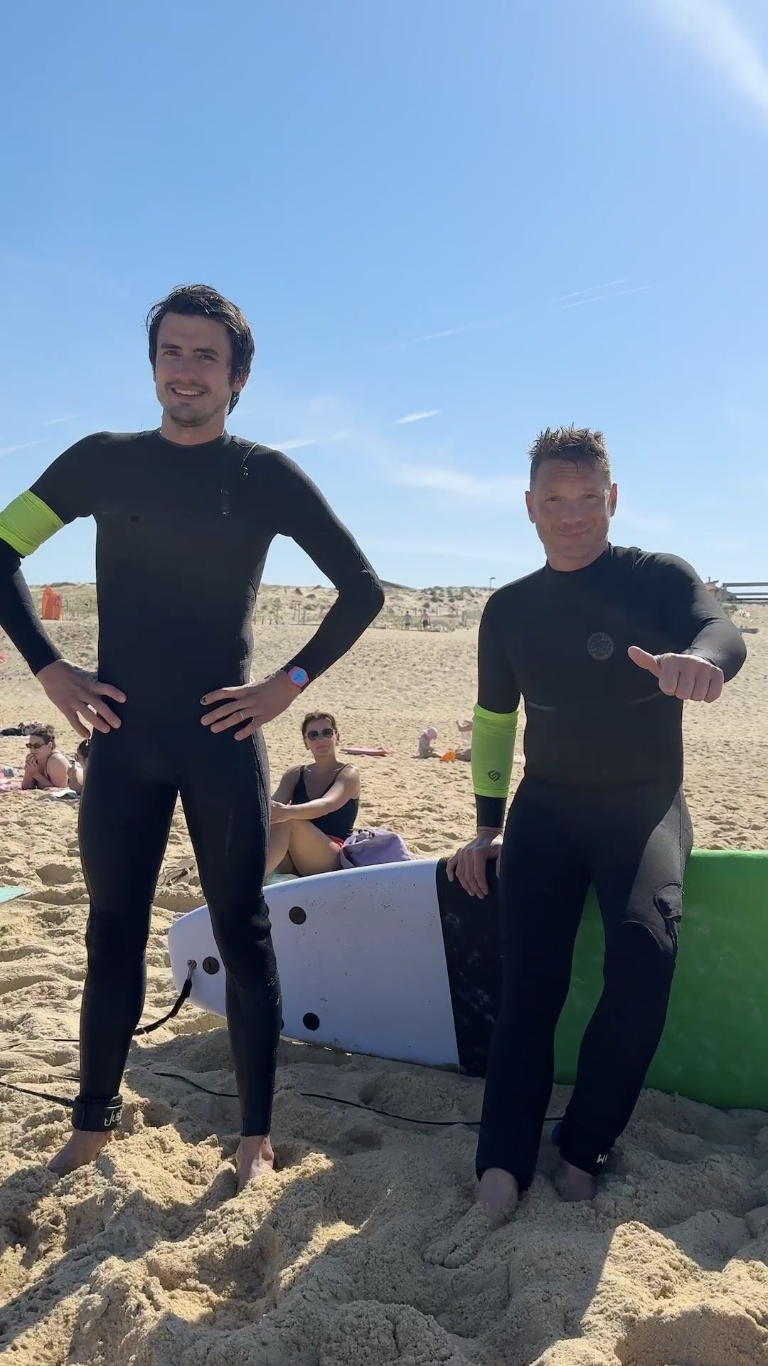 Deux élèves en combinaison sur la plage pendant un week-end coaching